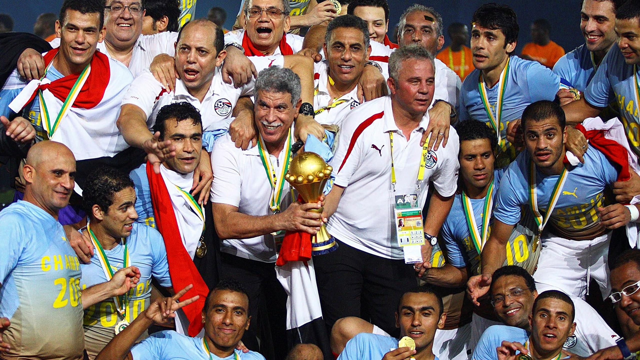 حسن شحاتة يمسك بكأس أفريقيا الذي حصده مع مصر 3 مرات في 2006 و2008 و2010 (X)